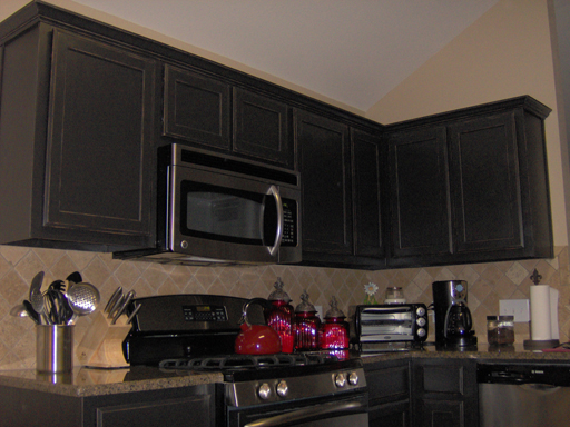 Detail of Kitchen Cabinets painted satin black then antiqued and distressed.